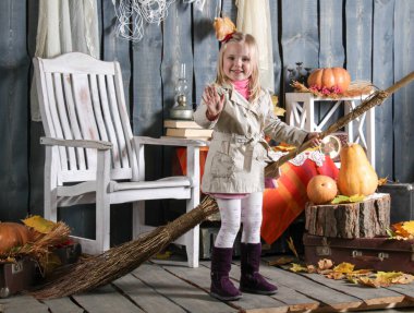 Kız cadılar bayramı süslemesinde süpürgeyle bir cadı tasvir ediyor.