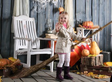 Kız cadılar bayramı süslemesinde süpürgeyle bir cadı tasvir ediyor.