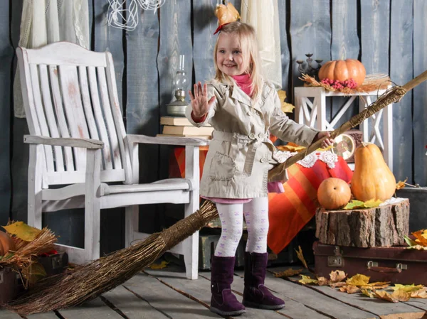 Kız cadılar bayramı süslemesinde süpürgeyle bir cadı tasvir ediyor.