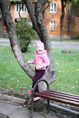 Pembeli kız ağaçta oturuyor.