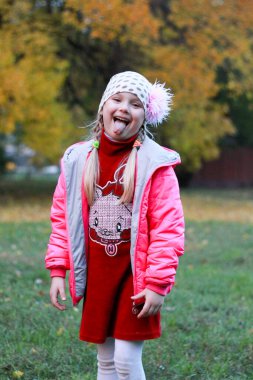 Kırmızı elbiseli kız doğanın arka planında poz veriyor.