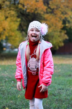 Kırmızı elbiseli kız doğanın arka planında poz veriyor.