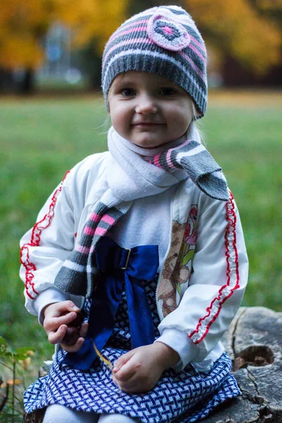 Una Ragazza Siede Tronco Albero Parco Autunnale Sorride Facce — Foto Stock