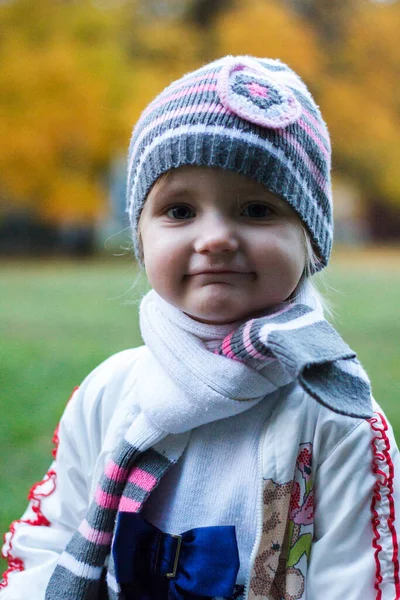 Uma Menina Senta Toco Árvore Parque Outono Sorri Faz Rostos — Fotografia de Stock