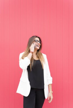 Hareket eden telefon içinde pembe duvar ile yakışıklı genç kadın