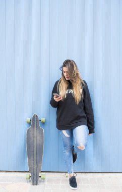 Cep telefonu kullaranarak güzel patenci kadın.