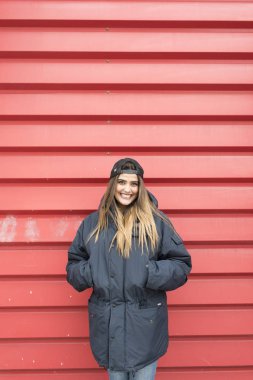 Kırmızı duvar önünde genç güzel kız