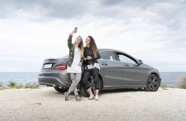 Genç kızların cep telefonuyla denize cepheli