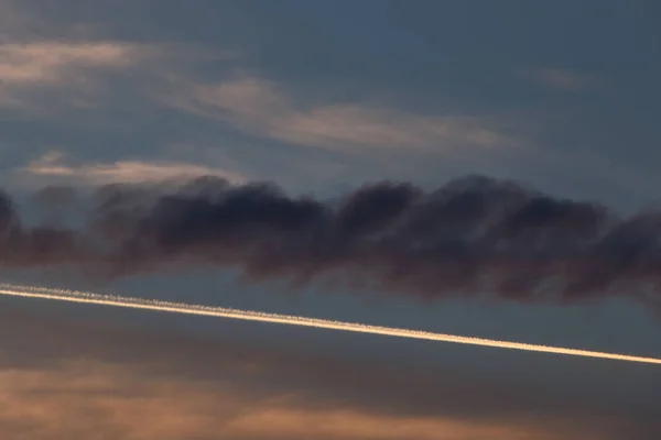 Plane trail at the sunset in the Roman sky