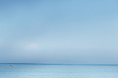 Mavi deniz, harika manzara, mavi gökyüzü ve mavi denizin üzerinde küçük bir tekne 