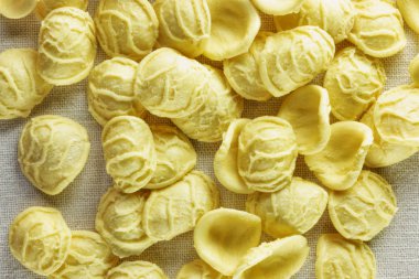 Orecchiette makarna üzerine beyaz bir bez, kenar ve pürüzlü bir yüzey ince merkezi ile küçük kulak şekil makarna