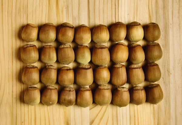 Lískové Ořechy Dřevěném Prkénku Plody Jsou Seřazeni Světlé Barvy Simmetry — Stock fotografie