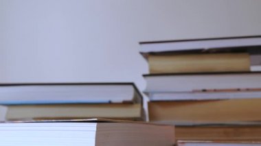 Ahşap masa üzerinde kitap yığınları, farklı kitap yığınları için odak bir kitaptan zaman atlamalı