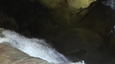Karanlık bir mağarada Şelale , kayalar yüzeyinde güzel su yansımaları