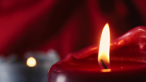 一支红色燃烧的蜡烛在深红色的背景 在背景小燃烧蜡烛 宏观摄影 — 图库视频影像