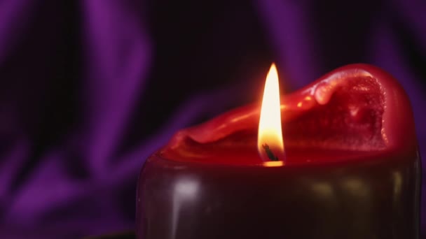 Uma Vela Queimando Vermelho Fundo Roxo Escuro Macrofotografia — Vídeo de Stock