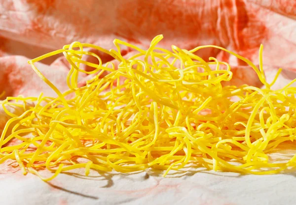 色の背景に調理されていないパスタフェットチーネ 卵と小麦粉で作られた黄色のフラット厚いパスタ — ストック写真