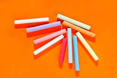 Turuncu arkaplanda çok renkli tebeşir