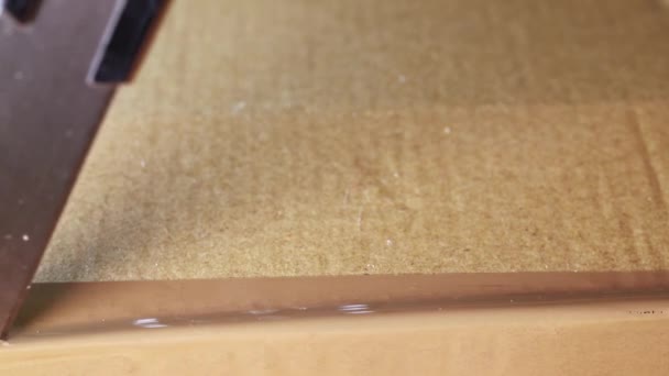 Membuka Kotak Kardus Coklat Menggunakan Pemotong Untuk Memotong Pita Perekat — Stok Video