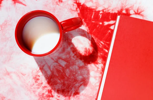 Röd mugg med mjölk på färgad bakgrund — Stockfoto