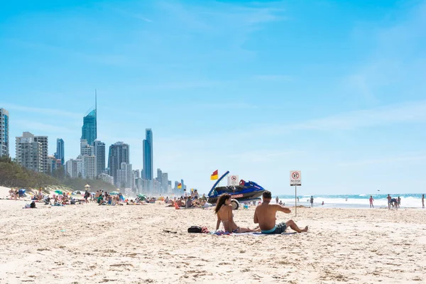 Gold Coast, Queensland, Avustralya - 2 Nisan 2015: kaç kadın ve adam bir sürü insan ile sahilde güneş güneşli meşgul gün tan almak