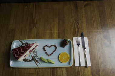 Tepsi dilimlenmiş çikolatalı kek ve turuncu duruyor