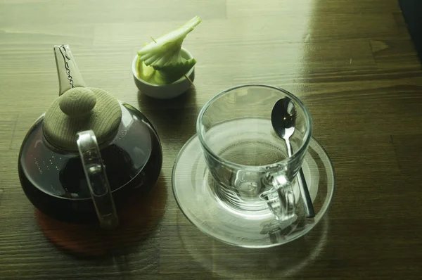 Tetera de vidrio tazas de vidrio y mesa marrón limón — Foto de Stock