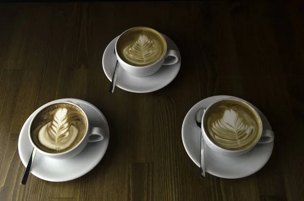 Three cups ready to be served coffee with milk — Stock Photo, Image