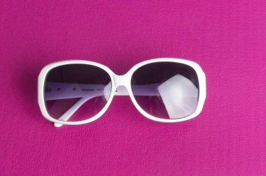 kırmızı arka plan ve beyaz çerçeveli siyah cam güneş gözlüğü