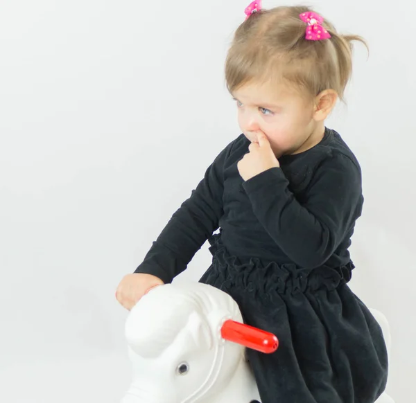 Mała dziewczynka jazda konna zabawka koń — Zdjęcie stockowe