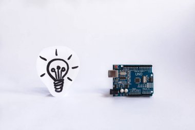 TERNOPIL, UKRAINE - APRIL 19, 2019: Arduino Uno. Arduino. Micro controller. Technology. Picture of a light bulb in the background. Concept. High intelligence. Idea. clipart
