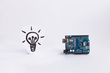 Ternopil, Ukrayna - 19 Nisan 2019: Arduino Uno. Arduino. Mikro kontrolör. Teknoloji. Arka planda bir ampul resmi. Dıy. Aı. Buhar.