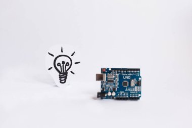 Ternopil, Ukrayna - 19 Nisan 2019: Arduino Uno. Arduino. Mikro kontrolör. Teknoloji. Arka planda bir ampul resmi. Dıy. Aı. Buhar.