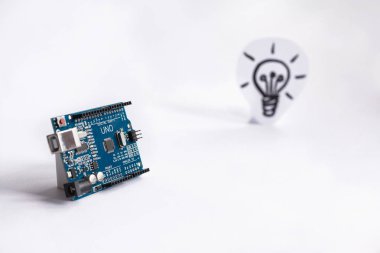 Ternopil, Ukrayna - 19 Nisan 2019: Arduino Uno. Arduino. Mikro kontrolör. Teknoloji. Arka planda bir ampul resmi. Fikir. Bilim. Endüstriyel.
