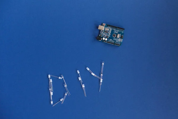 Ternopilu, Ukrajina-Květen 5, 2019: DIY slovo od diody a Arduino UNO na modrém pozadí. Arduino desce. Slovní slova pro Udělej to sám. místo pro text. Technologie. Elektronický výpočetní stroj — Stock fotografie