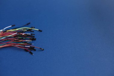 Mavi arka plan üzerinde elektronik robotik modüller için konektörlü çok renkli satılmamış ince teller