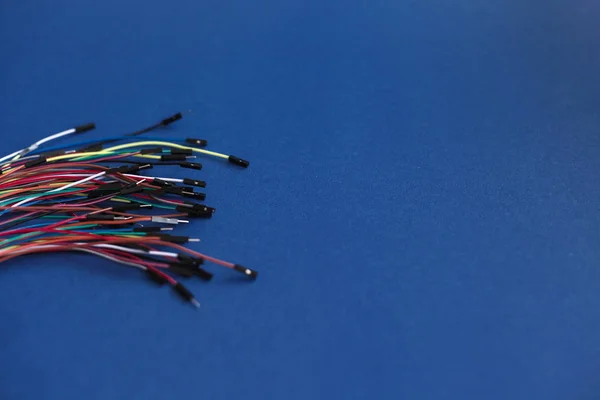 Fils minces multicolores sans fil avec connecteurs pour modules robotiques électroniques sur fond bleu — Photo