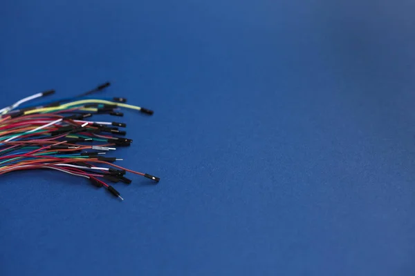 Wielokolorowe, cienkie, niesolone przewody ze złączami do elektronicznych modułów robotycznych na niebieskim tle — Zdjęcie stockowe