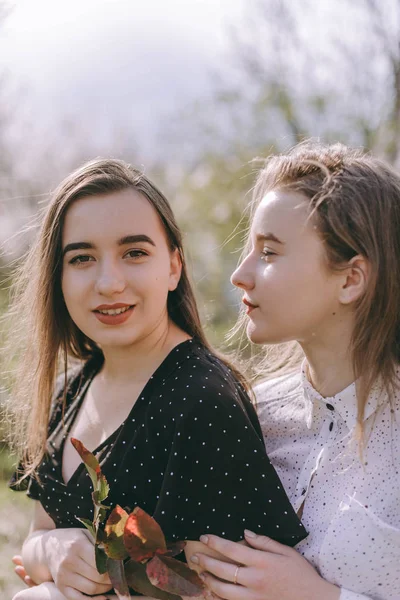 Porträt zweier hübscher junger Schwestern im grünen Frühlingsgarten — Stockfoto