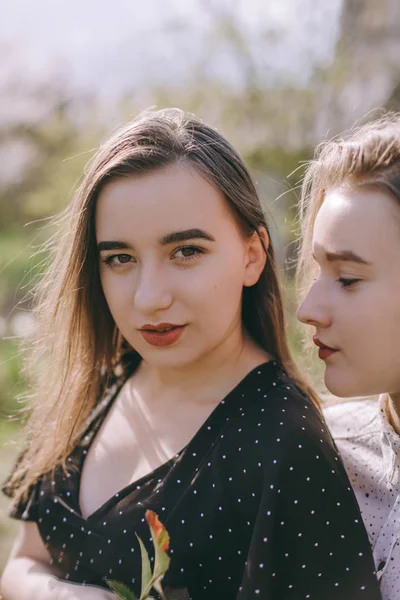 Portrét dvou krásných mladých sester v zelené jarní gardu — Stock fotografie