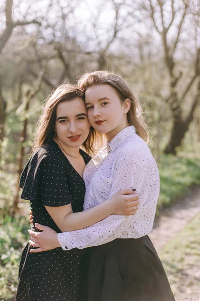 Porträt zweier hübscher junger Schwestern im grünen Frühlingsgarten — Stockfoto