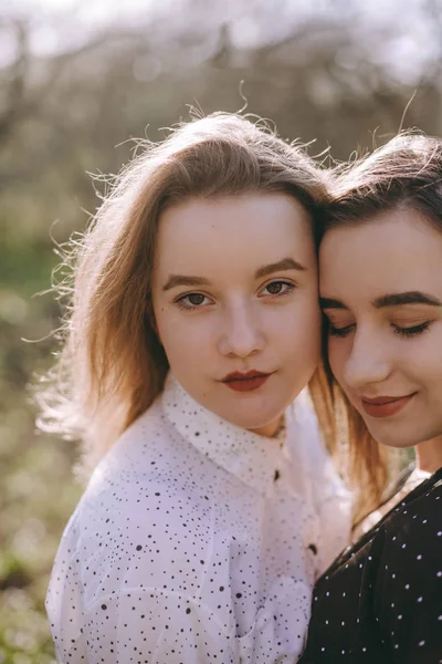 Porträtt av två vackra unga systrar i den gröna vårgard — Stockfoto