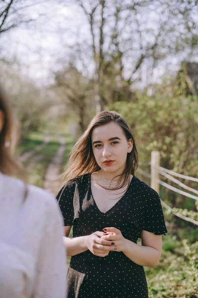 Porträt zweier hübscher junger Schwestern im grünen Frühlingsgarten — Stockfoto