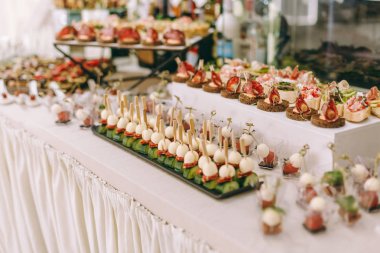 Burgerler, soğuk atıştırmalıklar, et ve salatalarla dolu açık büfe masası.