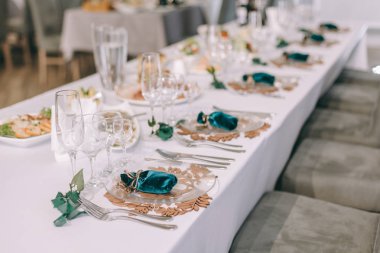 Yuvarlak ziyafet masası servis edilir. Düğün yemeği için Restoran İç, misafirler için hazır. Çiçek aranjmanı ile dekore edilmiştir. Catering konsepti. Sunucu tarafı masada bir plaka üzerinde misafirler için iltifat