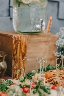 Güzel dekore edilmiş yemek sofrası farklı atıştırmalıklar ve sandviçli aperatifler.