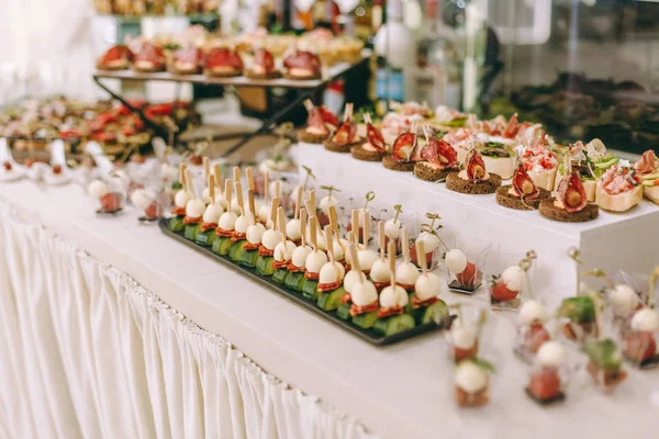 Burgerler, soğuk atıştırmalıklar, et ve salatalarla dolu açık büfe masası.