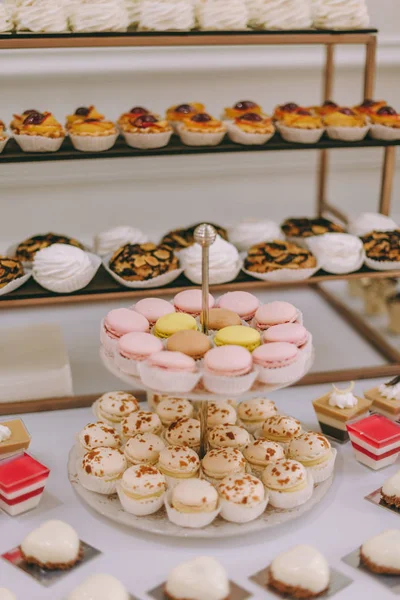 Güzel dekore edilmiş yemek masası. Hamburger, profiterol, salata ve soğuk atıştırmalıklarla. Masada çeşitli lezzetli atıştırmalıklar var.