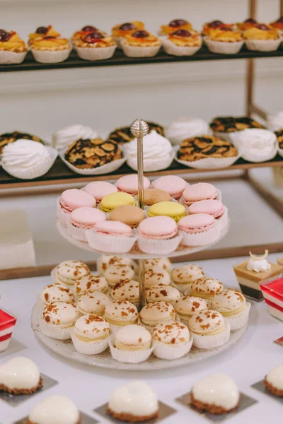 Güzel dekore edilmiş yemek masası. Hamburger, profiterol, salata ve soğuk atıştırmalıklarla. Masada çeşitli lezzetli atıştırmalıklar var.