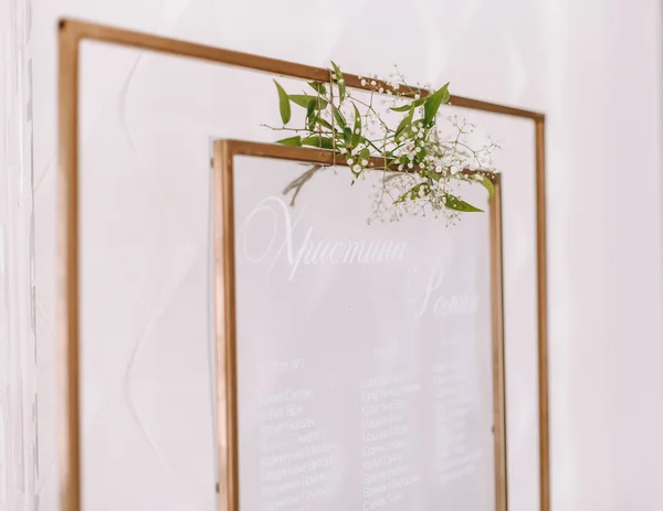 Κατάλογος, σχέδιο, διάγραμμα του καθιστικού των καλεσμένων στα τραπέζια του εστιατορίου. Τραπέζια για τους καλεσμένους του γάμου στο καβαλέτο στη γαμήλια δεξίωση. Το πλαίσιο είναι διακοσμημένο με πράσινα λουλούδια και πράσινο. — Φωτογραφία Αρχείου